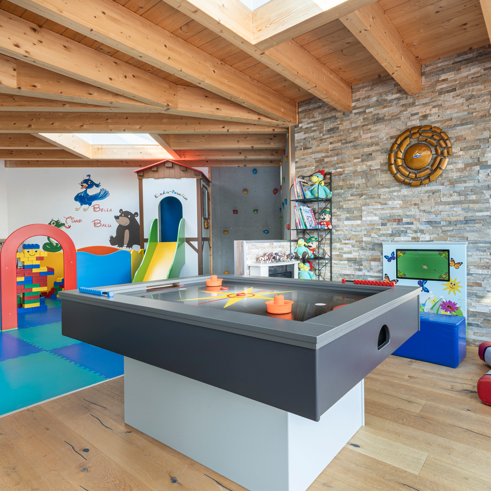Kinderspielzimmer in Mimis Kinderspielwelt im Alpenapart in Ladis mit Spielzeug und Rutsche.