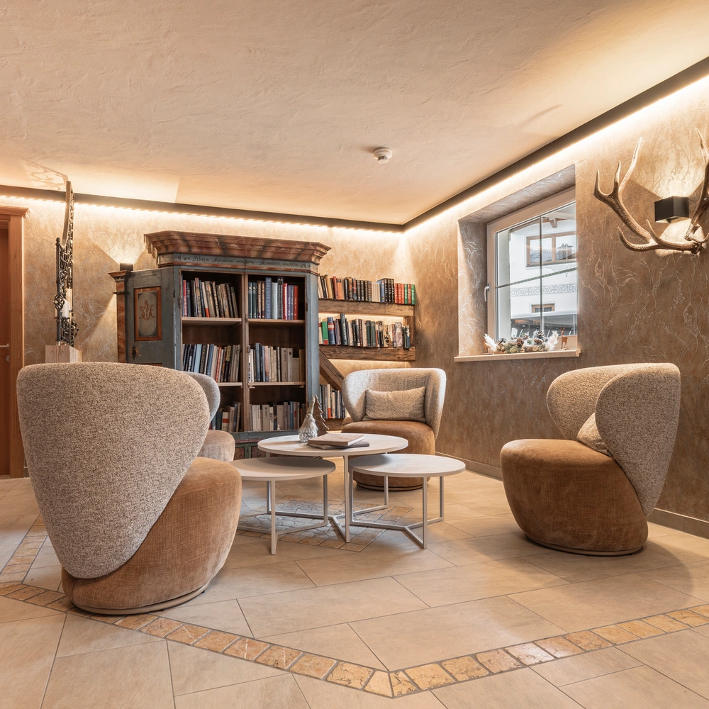 Gemütliche Leseecke in Mimis Kinderspielwelt im Alpenapart in Ladis mit Stühlen und Bücherregalen.